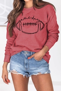 Détail de l'imprimé rugby Game Day sur un sweat brique avec un short en jean usé