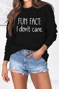 Close-up of Fun Fact I Don't Care slogan print on black long sleeve sweatshirt