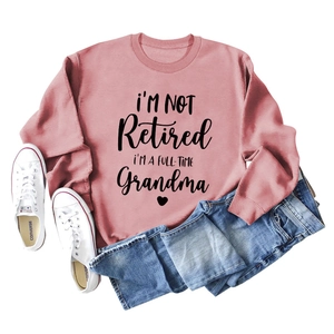 Detailed flatlay of dusty rose sweatshirt with full-time grandma slogan and jeans