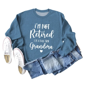 Flat lay of blue grandma slogan sweatshirt with denim jeans and white canvas sneakers
