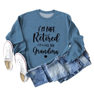 Flat lay of a blue sweatshirt with I'm Not Retired quote and distressed denim jeans