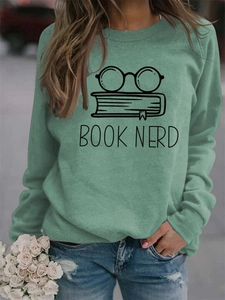 Detail of mint green Book Nerd sweatshirt featuring minimalist glasses and book graphic