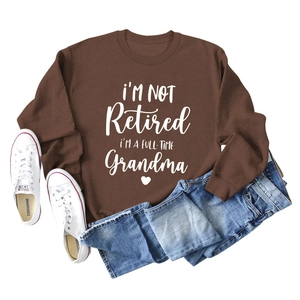 Flat lay of brown grandma sweatshirt with blue jeans and white high-top canvas shoes