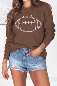 Détail de l'imprimé football Game Day sur sweat marron et short en jean effiloché