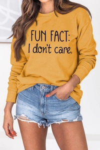 Detail of Fun Fact I Don't Care slogan printed on a mustard yellow crewneck sweatshirt