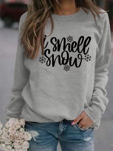 Detail of the 'I smell snow' script and snowflake print on light gray sweatshirt fabric