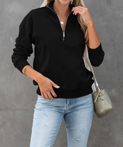 Dettaglio felpa nera con mezza zip in metallo e polsini a costine stile casual