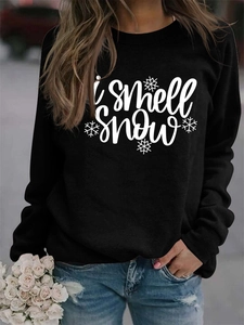 Detail of the 'I smell snow' white cursive print on a black long sleeve sweatshirt