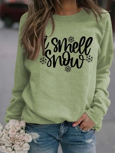 Detail of light green round neck sweatshirt featuring 'i smell snow' text and snowflake