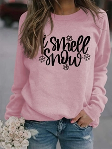 Detail of light pink sweatshirt featuring 'i smell snow' text and snowflake print