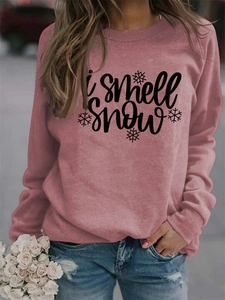 Detail of 'I smell snow' print and snowflake graphic on pink crewneck sweatshirt