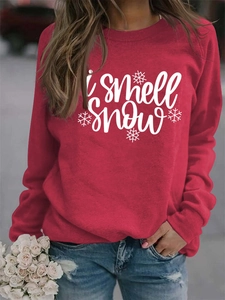 Close-up of I Smell Snow cursive text and snowflake print on red crewneck sweatshirt