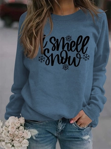 Detail of greyish blue sweatshirt featuring 'i smell snow' text and snowflake print