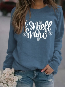 Detail of blue crewneck sweatshirt with 'i smell snow' text and white snowflake prints