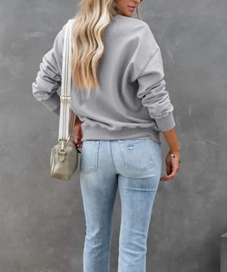 Vista posteriore di una felpa grigia con jeans alla moda e borsa a tracolla verde