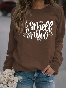 Detail view of I Smell Snow graphic print and snowflake patterns on brown sweatshirt