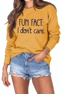 Detail of Fun Fact I Don't Care slogan print on ginger yellow crewneck sweatshirt