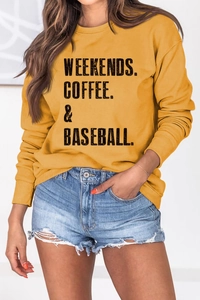 Detail of the Weekends Coffee Baseball slogan print on a yellow crewneck sweatshirt