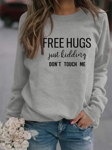 Detail shot of grey Free Hugs sweatshirt with black lettering and casual distressed jeans