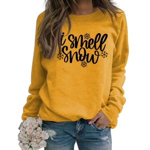 Detail showing i smell SNOW printed lettering and snowflake pattern on yellow sweatshirt