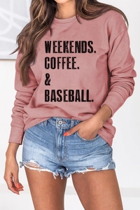 Detail of pink sweatshirt featuring Weekends Coffee Baseball text and denim shorts