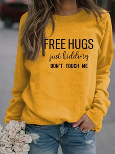 Detail of yellow round neck sweatshirt with Free Hugs slogan print on soft cotton fabric