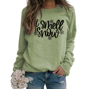 Detail of green crewneck sweatshirt with 'I smell Snow' text and snowflake pattern