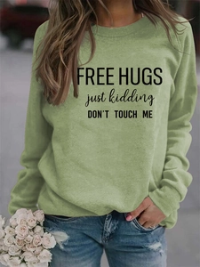 Detail of light green sweatshirt with Free Hugs slogan and soft cotton texture
