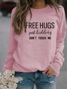 Pink crew neck sweatshirt featuring FREE HUGS text print paired with ripped blue jeans