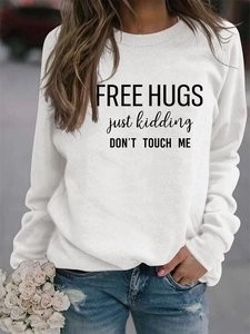 Close-up of white crewneck sweatshirt featuring black Free Hugs printed typography design