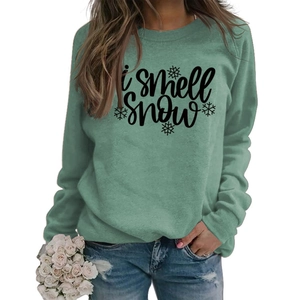 Detail of I smell Snow lettering and snowflake print on mint green sweatshirt
