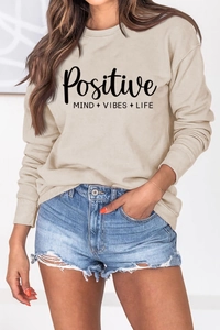 Détail de l'imprimé Positive Mind Vibes Life sur un sweat à manches longues beige