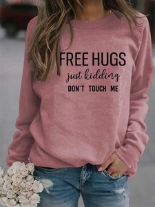 Detail of dusty rose sweatshirt featuring Free Hugs slogan and dropped shoulders