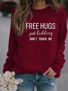 Detail of burgundy sweatshirt with white Free Hugs Just Kidding letter printing