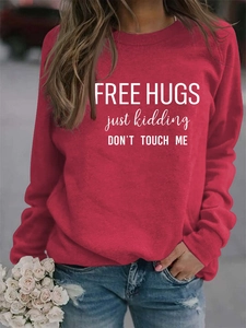 Detail of red crew neck sweatshirt with FREE HUGS printed slogan and long sleeves