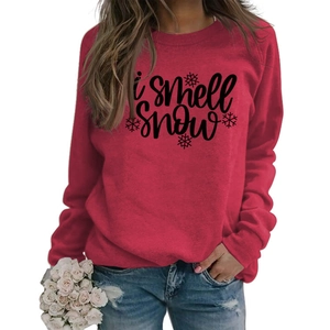 Detail of red crewneck sweatshirt featuring I Smell Snow text and snowflake patterns