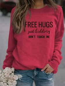 Close-up of red long sleeve sweatshirt with black Free Hugs humor slogan on the front
