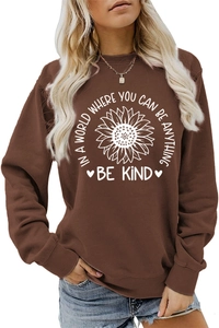 Detail of sunflower print and Be Kind slogan on brown crewneck sweatshirt for women