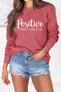 Gros plan de l'imprimé Positive Mind Vibes Life sur le sweat-shirt terre cuite