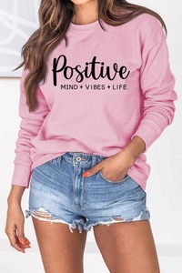 Gros plan du sweat rose avec l'imprimé noir slogan Positive Mind Vibes Life