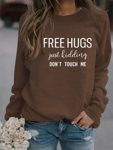Detail of Free Hugs slogan print on brown long sleeve crewneck cotton sweatshirt