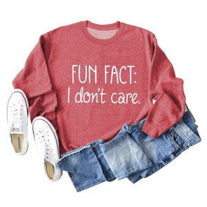 Detail view of red Fun Fact I Don't Care sweatshirt paired with blue jeans and sneakers
