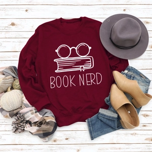 Close-up of Book Nerd print on burgundy sweatshirt with autumn fashion accessories layout