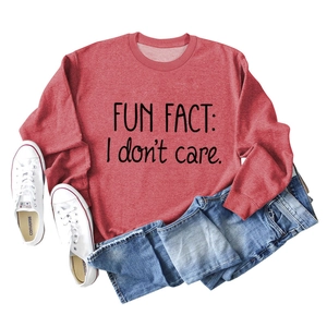 Detail of red crewneck sweatshirt featuring black Fun Fact I Don't Care print text