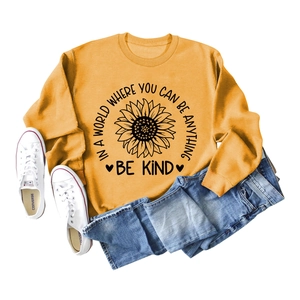 Close-up of mustard yellow sweatshirt with sunflower print and light wash denim jeans
