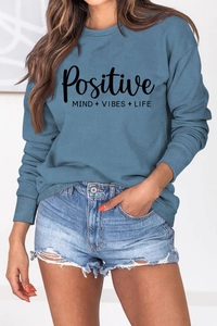 Détail de l'imprimé Positive Mind Vibes Life sur un sweat bleu à manches longues en coton
