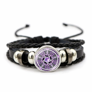 Détail du charme en verre cercle magique sur un bracelet multicouche en cuir noir