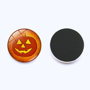 Close-up of Halloween pumpkin face glass fridge magnet showing glossy surface and magnetic back