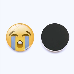 Detail of round 30mm glass fridge magnet showing crying emoji face and magnetic back