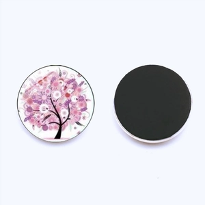 Macro view of 25mm round glass Tree of Life magnet showing both floral pattern and magnetic back